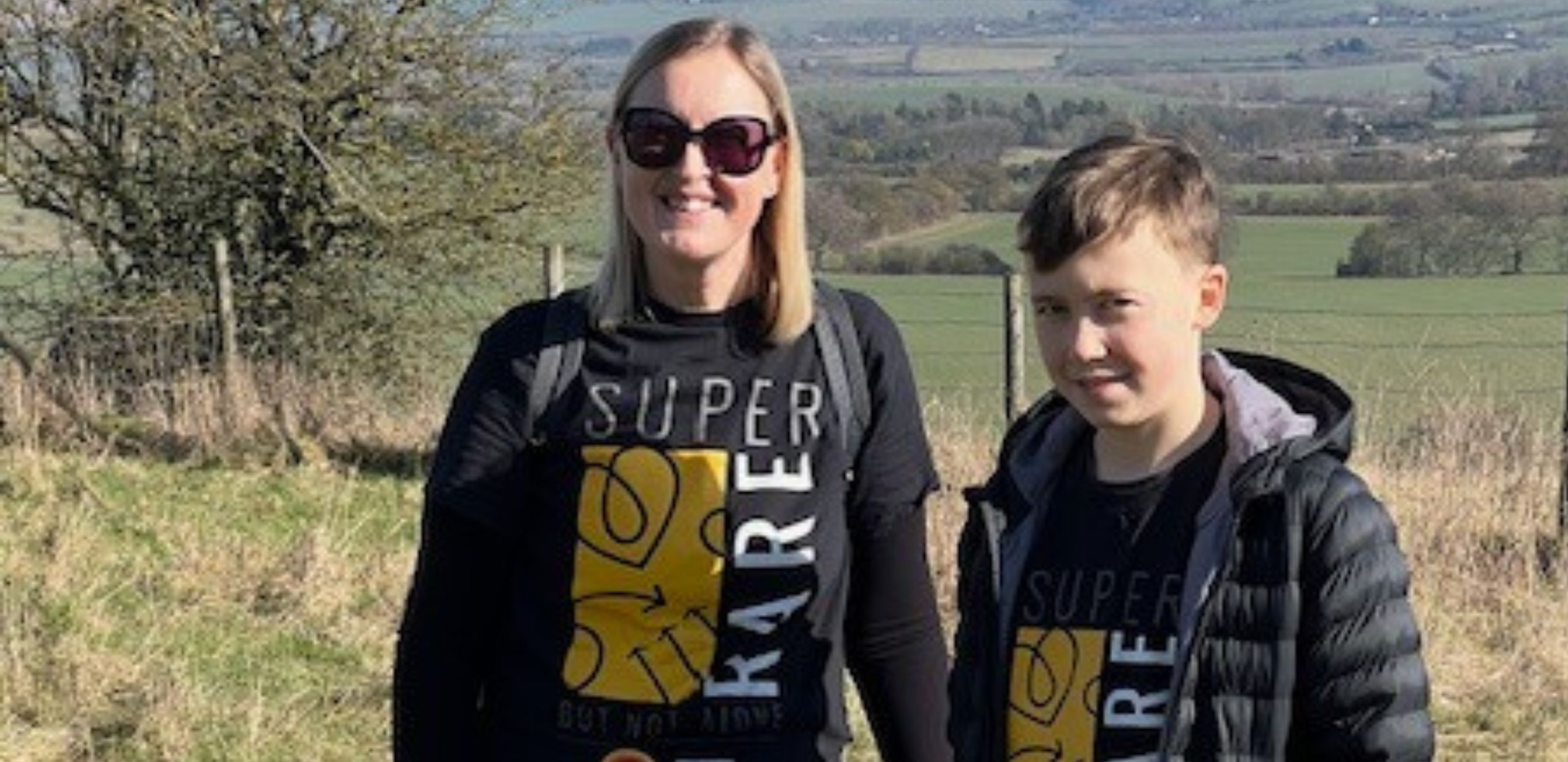 Lucas and his mum wearing 'super rater' tshirts standing in front of a field