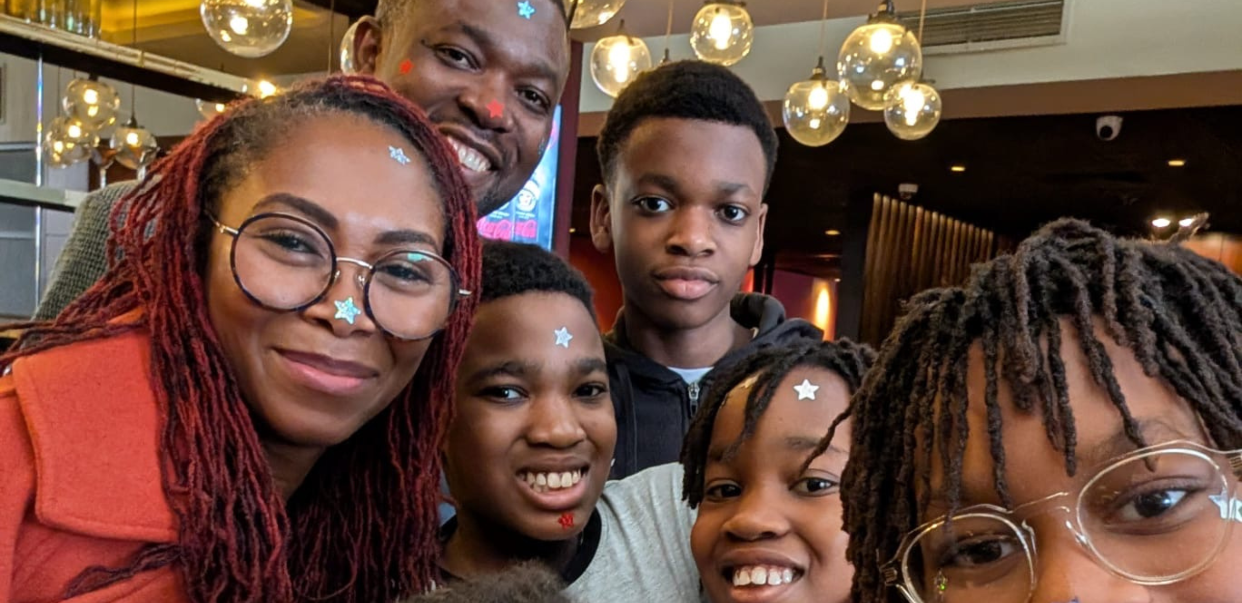 Six people smiling with star stickers on their foreheads